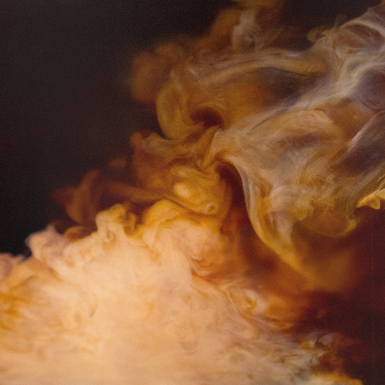 Close-up of smoke creating abstract patterns of light brown and white